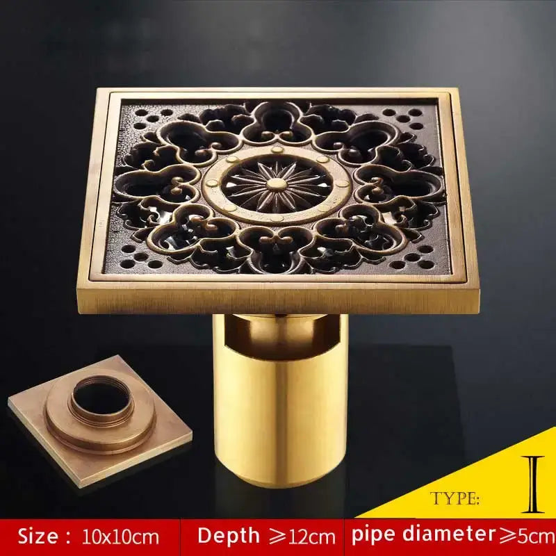 Decorbites™ antique brass fish style square shower drain with ornate floral cutout and central starburst motif
