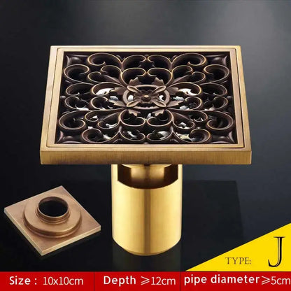 Square brass bathroom shower drain with antique brass fish style ornate floral cutout and matching cylindrical pipe