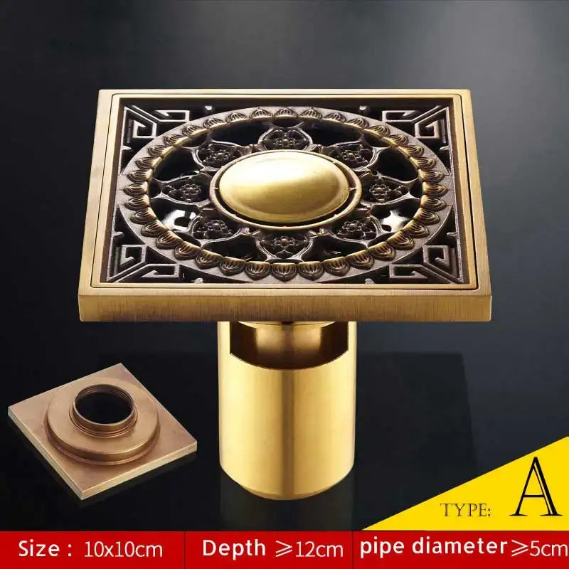 Brass square shower drain with ornate floral and geometric embossed design in antique brass fish style finish