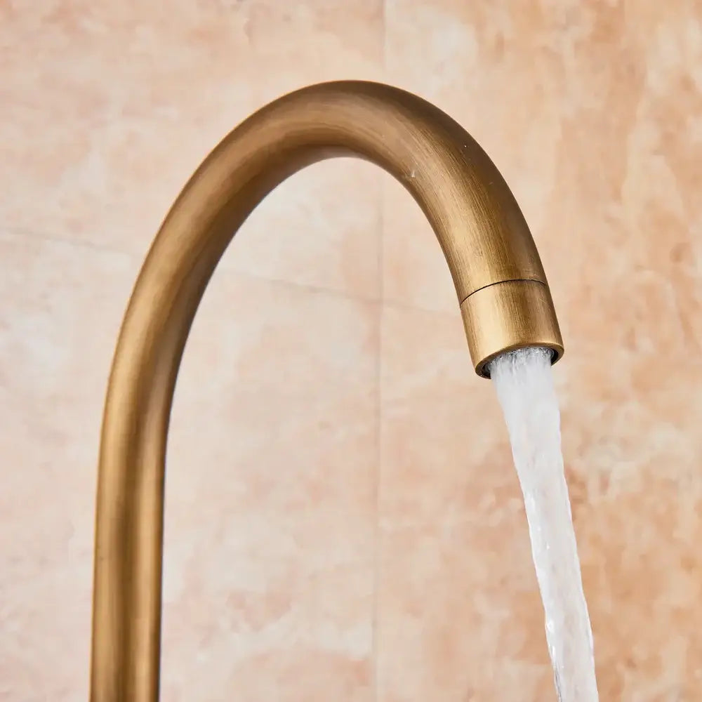 DecorBites antique brass floor mount tub faucet with swivel spout and mixer tap featuring a sleek curved design
