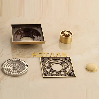 Decorbites™ antique brass floor drain featuring ornate bronze square assembly with decorative flower art grates