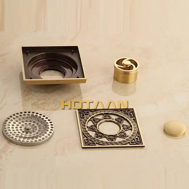 Decorbites™ antique brass floor drain featuring ornate bronze square assembly with decorative flower art grates