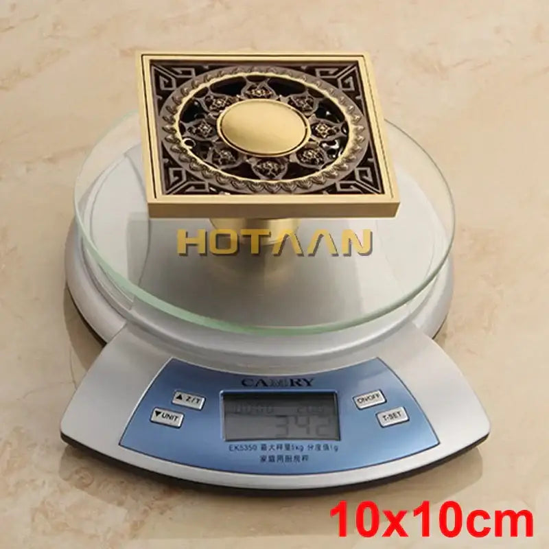 Decorbites™ antique brass floor drain with ornate flower art filigree and central circular medallion design