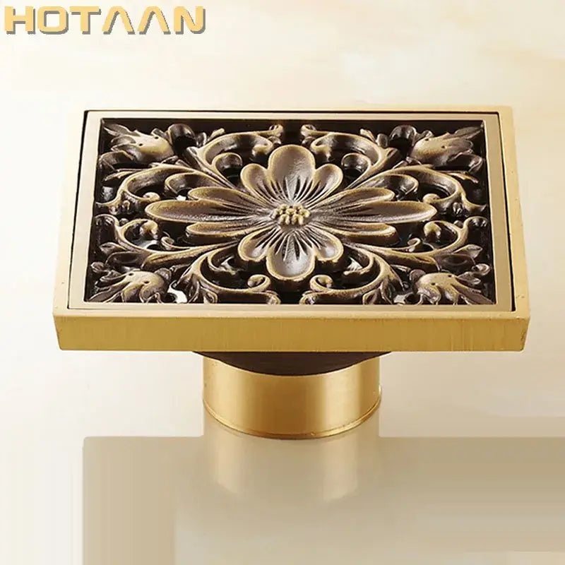 Gold-colored antique brass floor drain with intricate flower art relief design for bathroom floor waste grate