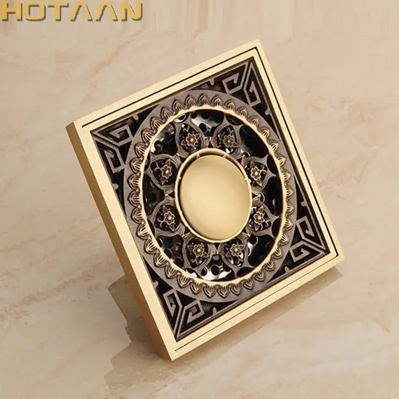 Decorbites antique brass flower art floor drain with brass finish and intricate black and gold filigree design