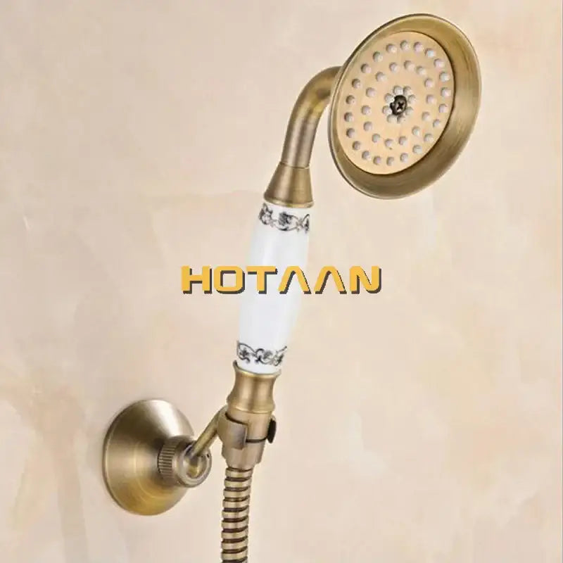 Antique brass hand held shower head kit with white ceramic handle and black floral patterns for wall mounted bathtub