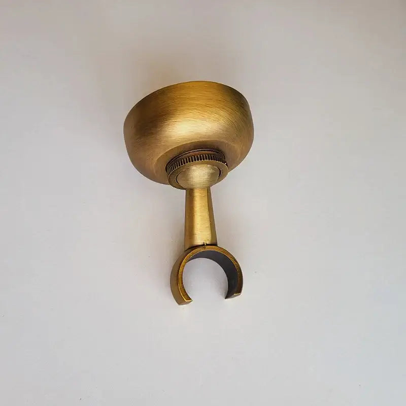 Antique brass DecorBites hand shower holder with rounded top, threaded adjustment, and u-shaped pedestal bracket