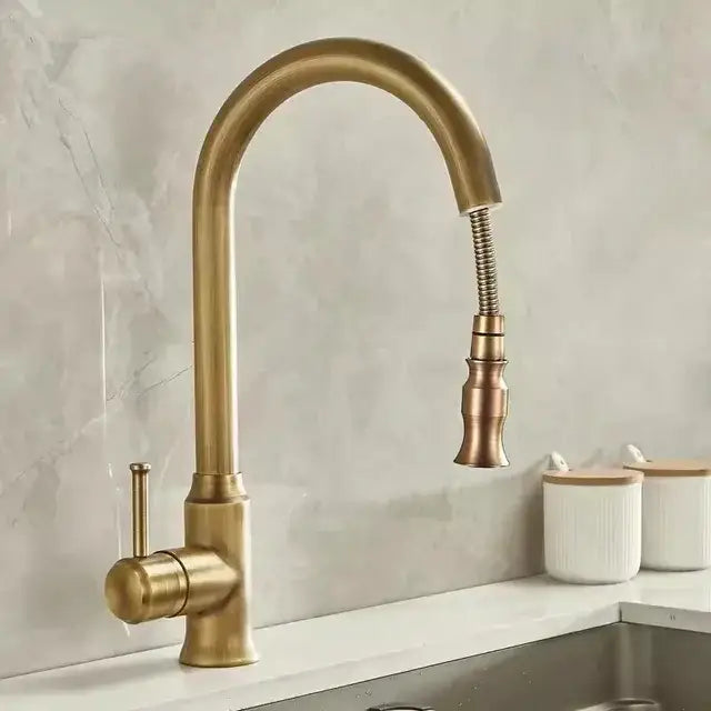 Decorbites™ antique brass kitchen faucet with brass finish, curved spout, and extendable pull-down spray head