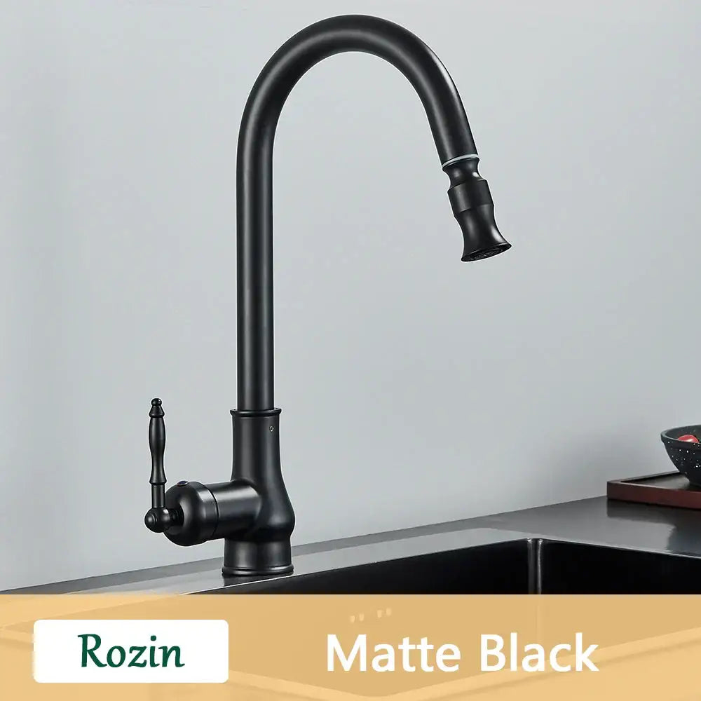 Matte black rozin kitchen faucet with a curved spout and ornate handle in antique brass kitchen style by decorbites