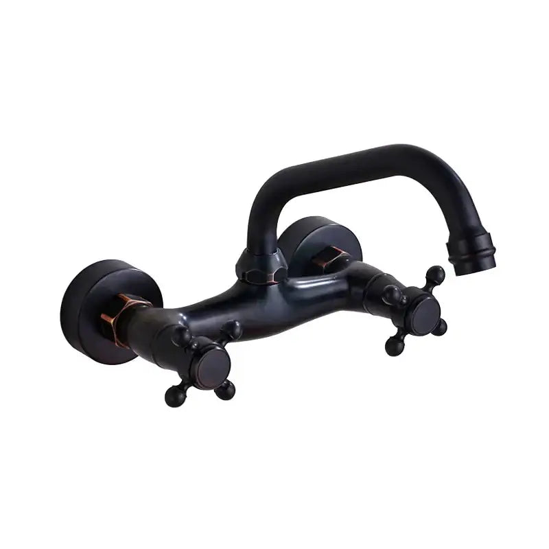 Black matte wall-mounted faucet with two cross handles and curved spout contrasted with antique brass kitchen faucet design