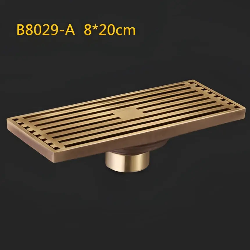 Decorbites antique brass linear shower floor drain with brass rectangular slatted art carved cover and cylindrical base