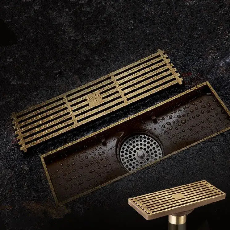 DecorBites antique brass linear shower floor drain with brass-colored rectangular slatted grate and circular overflow