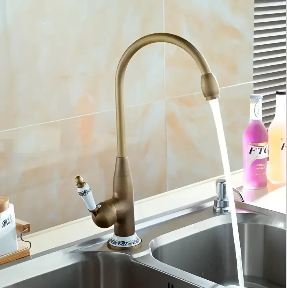 Decorbites antique brass porcelain basin mixer with curved spout and decorative porcelain handle for kitchen use
