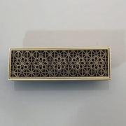 Bronze-colored antique brass floor drain strainer with intricate floral cutout and brushed finish for deodorization