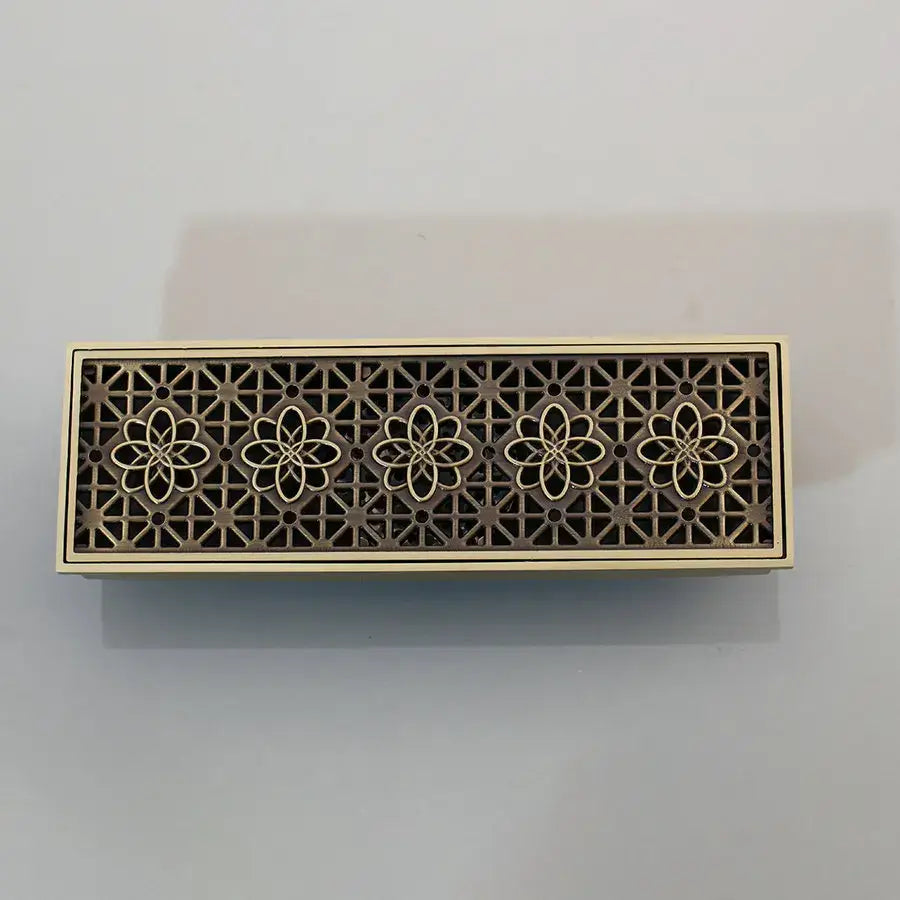 Bronze-colored antique brass floor drain strainer with intricate floral cutout and brushed finish for deodorization