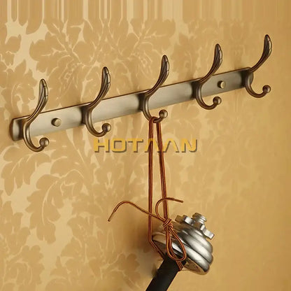 A sleek brushed metallic wall-mounted antique brass robe hook with five ornate hooks from decorbites bathroom accessories