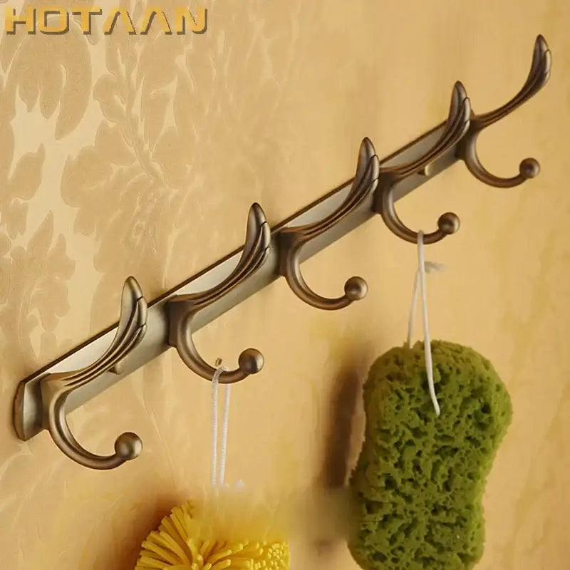 Antique brass robe hook wall-mounted with five ornate hooks for bathroom accessories and hardware by DecorBites