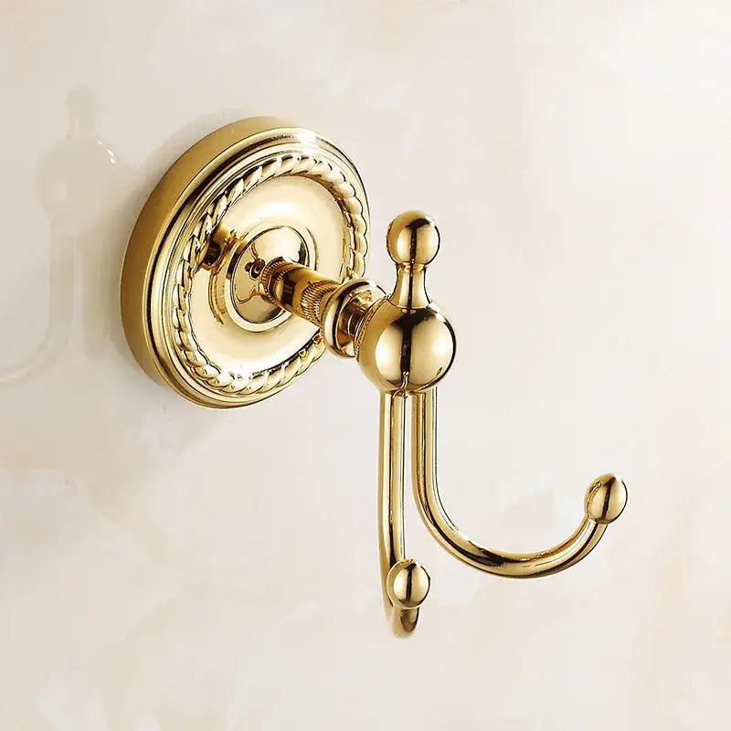 Brass double robe hook with ornate rope-patterned circular backplate and polished spherical accents in antique brass finish