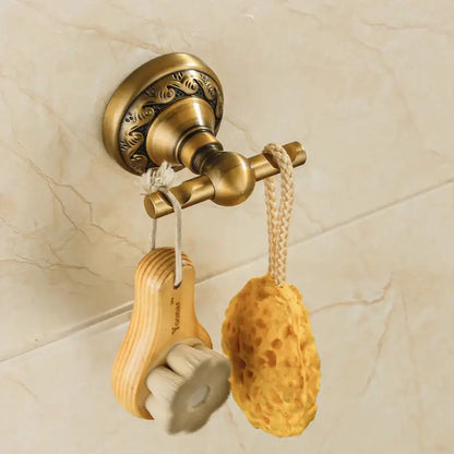 Decorbites™ antique brass robe hook wall-mounted towel rack with ornate detailing holding brush and yellow sponge
