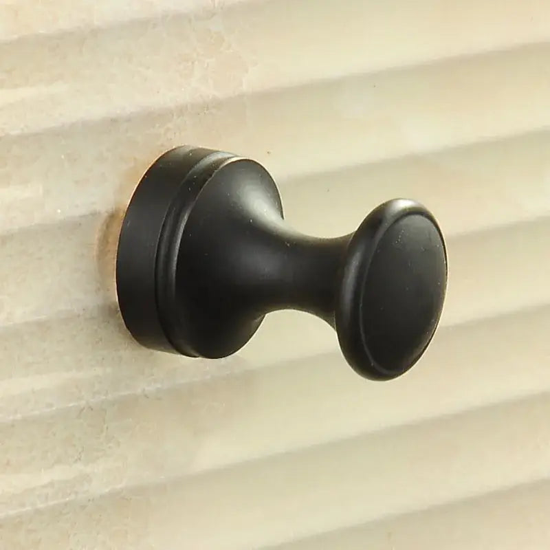 Black matte-finished wall-mounted robe hook with a classic rounded design for bathroom or coat hanging use