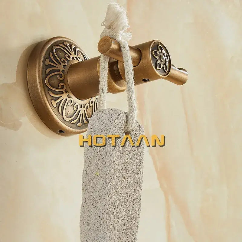 Antique brass robe hook by decorbites with ornate floral detailing and a pumice foot file hanging on the hook