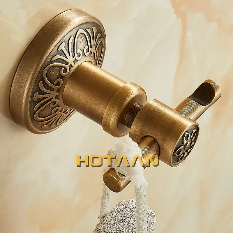 Decorbites™ antique brass robe hook with ornate scrollwork and textured matte finish for wall mounted use