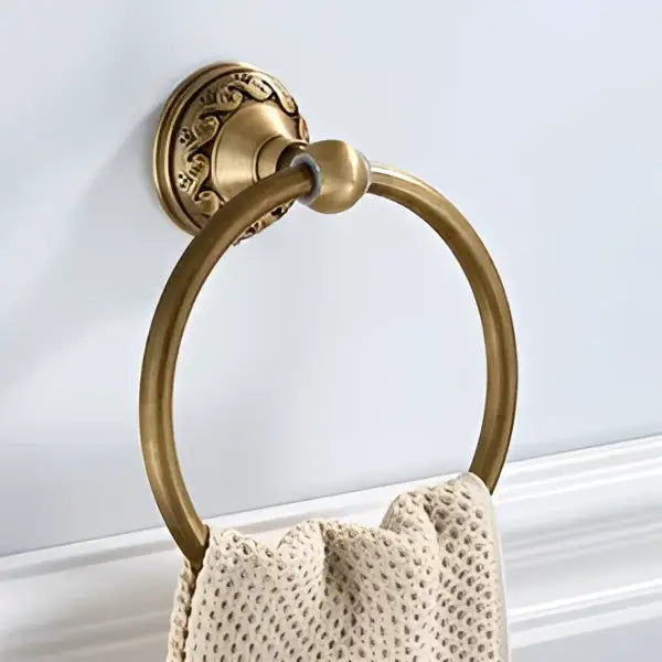 DecorBites™ antique brass round towel ring with ornate wall mount holding a textured beige towel for elegant bathrooms