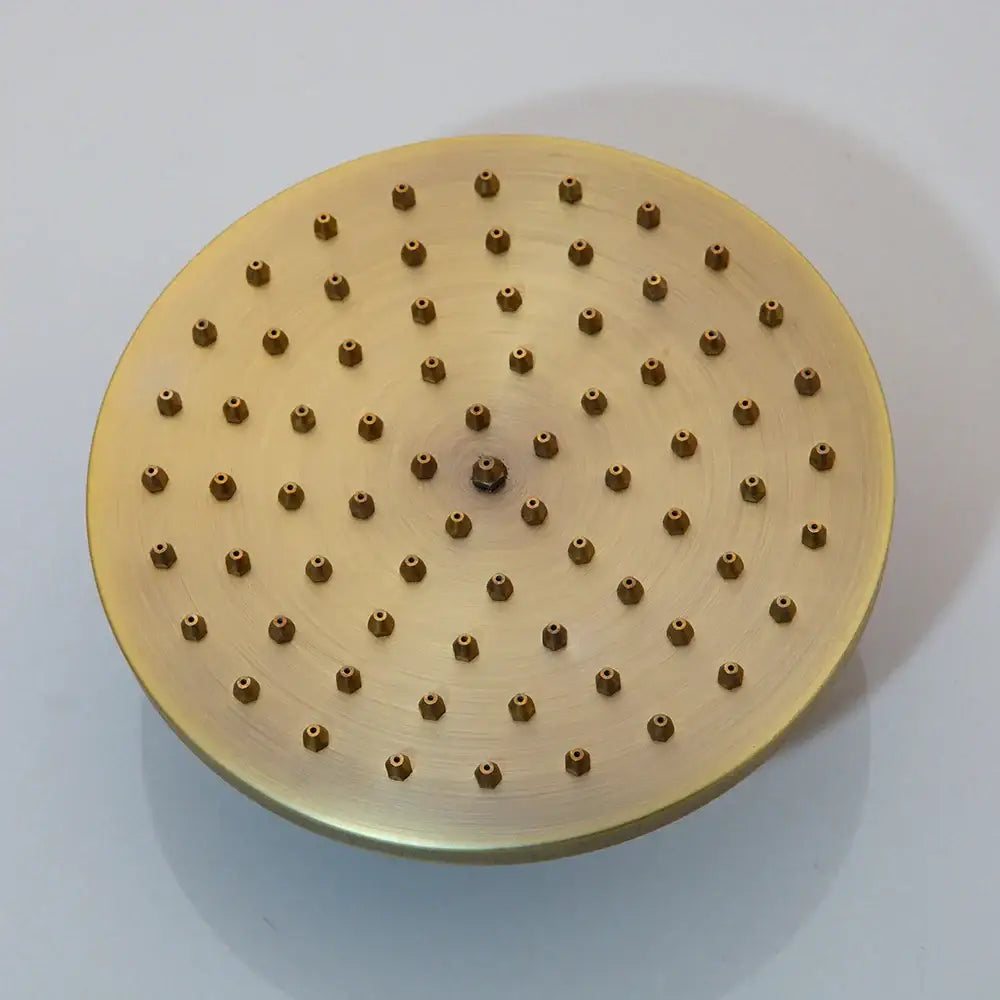 Gold-colored circular showerhead with brushed metal finish and multiple nozzles in DecorBites™ shower faucet set