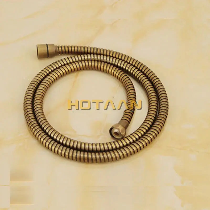 Brass-colored flexible shower hose with coiled design and metallic connectors in DecorBites antique brass shower faucet set