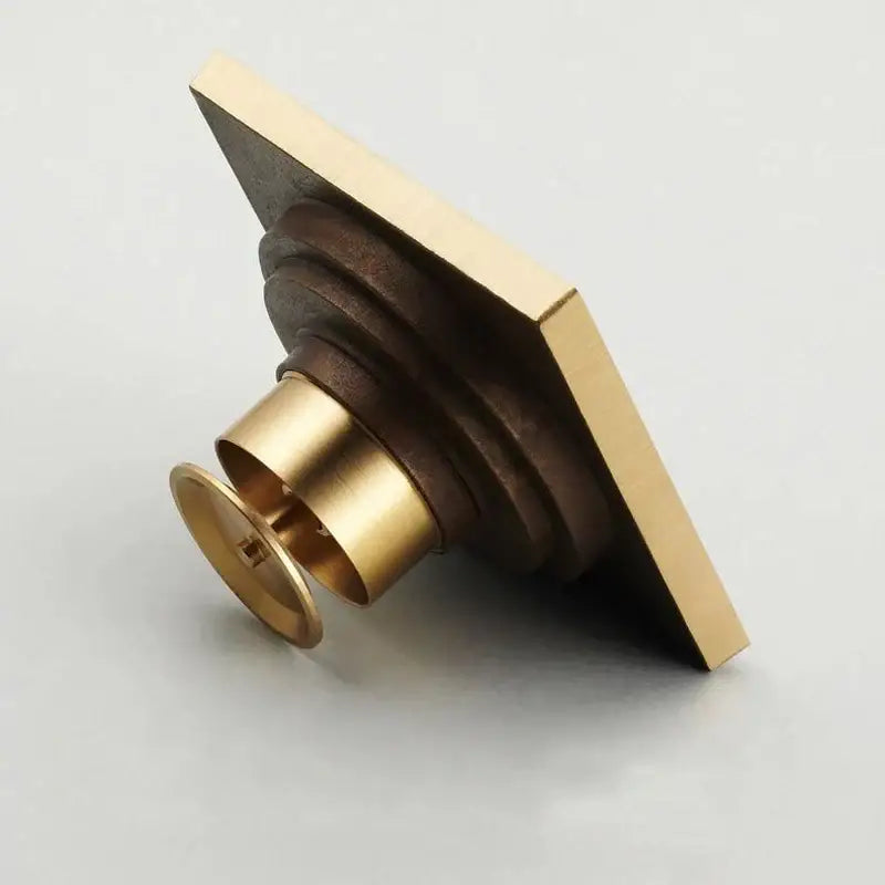 DecorBites antique brass shower floor drain with tiered fluted design and circular overflow hole 10cm square grate