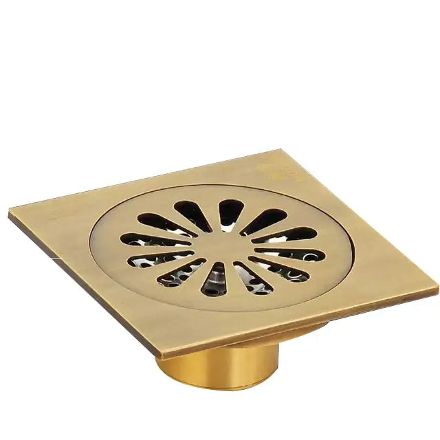 Brass-colored antique brass shower floor drain with sunburst-patterned square grate for decorbites waste strainer cover