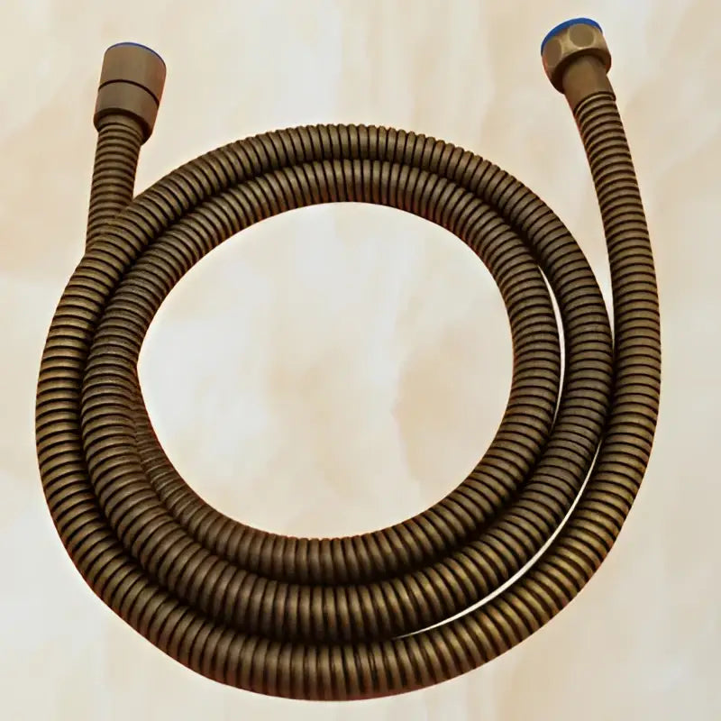 Bronze-colored corrugated flexible hose with metallic connectors from the decorbites antique brass shower set
