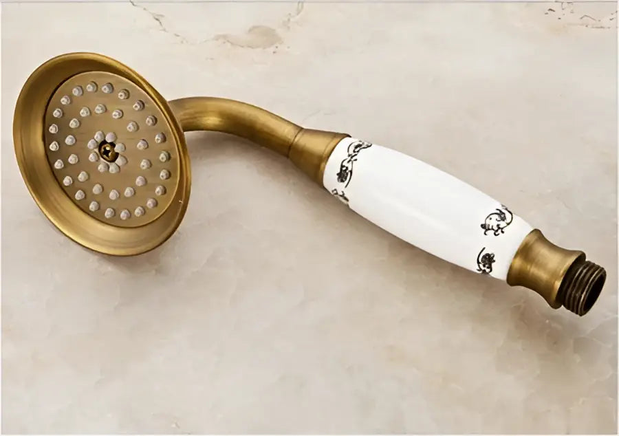 Antique brass shower set featuring an 8 inch rain head with a white ceramic handle adorned with black floral patterns