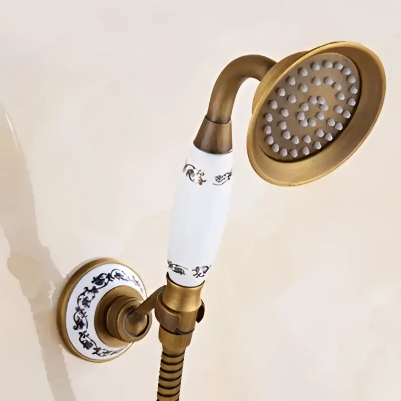 Decorbites™ antique brass shower set with 3-way diverter features an antique brass showerhead with white ceramic handle and blue floral patterns