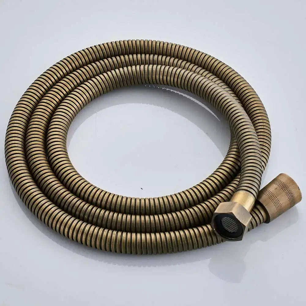 A coiled brass-colored flexible shower hose with ribbed texture and hexagonal connector for antique brass shower set