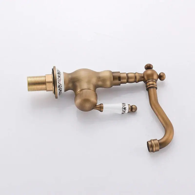 DecorBites™ antique brass single handle basin faucet with ornate detailing and white ceramic handles with black floral patterns