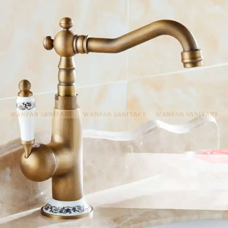 Decorbites antique brass single handle basin faucet with ornate ceramic knobs and black floral detailing on base
