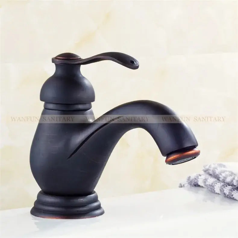 Decorbites antique brass single handle deck mount bathroom sink faucet with curved spout and decorative base in bronze finish