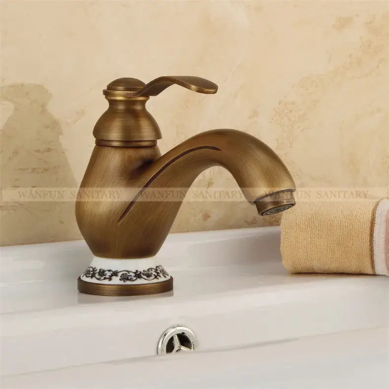 DecorBites™ antique brass single handle deck mount bathroom sink faucet with ornate black floral ceramic base detailing