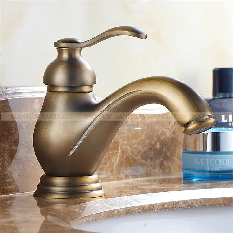 DecorBites antique brass single handle deck mount bathroom sink faucet with curved spout and decorative base
