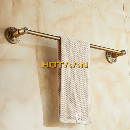 DecorBites™ antique brass single towel bar with ornate mounts holding a textured beige towel wall mounted holder