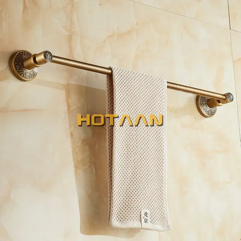 DecorBites™ antique brass single towel bar with ornate mounts holding a textured beige towel wall mounted holder