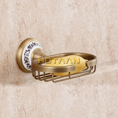 Antique brass soap holder by decorbites featuring a white ceramic backplate with black floral patterns and a yellow soap bar