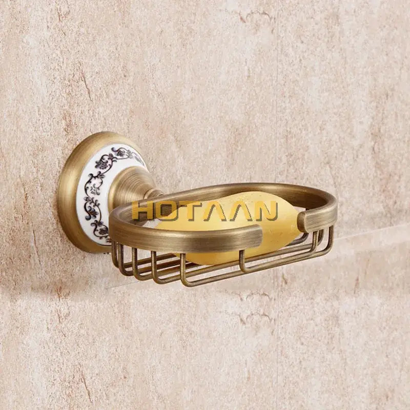 Antique brass soap holder by decorbites featuring a white ceramic backplate with black floral patterns and a yellow soap bar