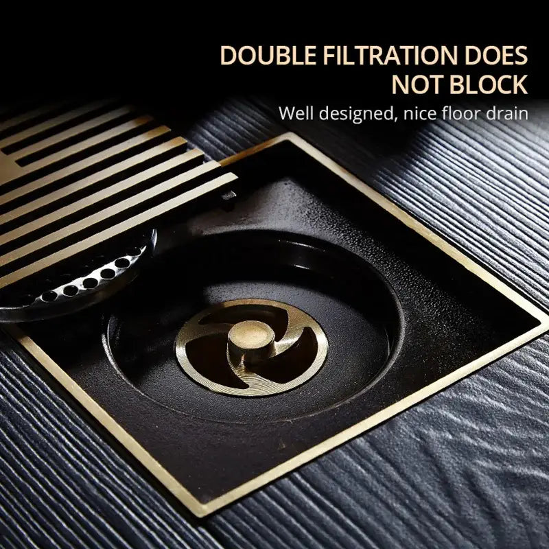 Decorbites™ antique brass square bath drain strainer featuring black floor drain with gold edges and removable slatted filter