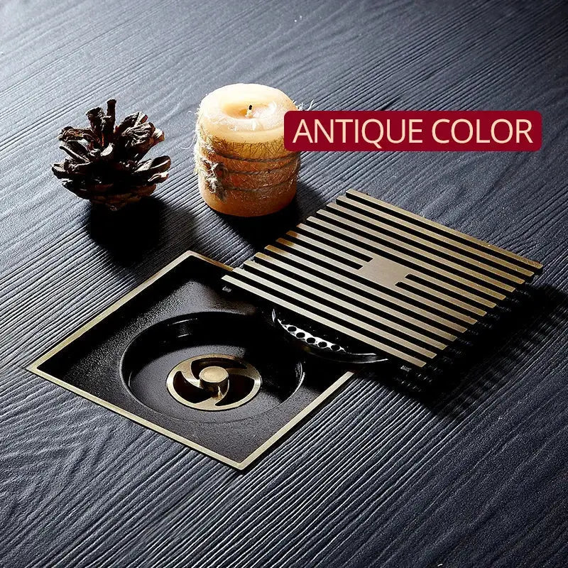 Antique brass square floor drain strainer with slatted grate and central turbine design for brass square bath use