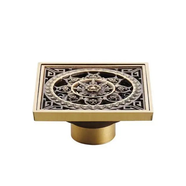 Square fish carved antique brass floor drain with intricate floral and geometric embossed patterns by DecorBites™