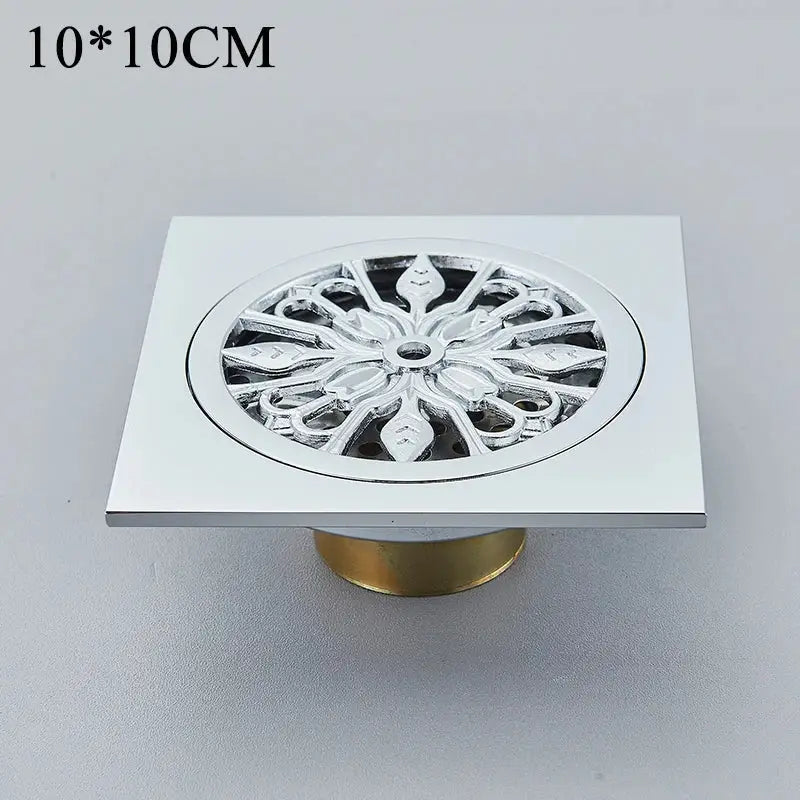 Decorbites™ antique brass floor drain with square fish carved chrome grate and brass-colored base for bathroom use