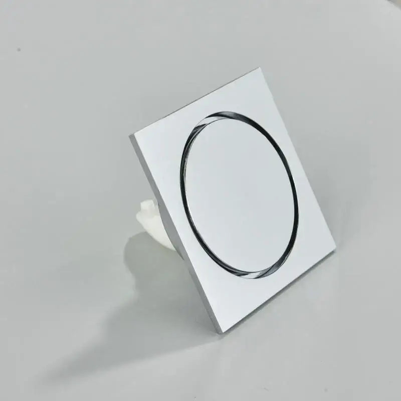 Chrome-finished square bathroom floor drain with sleek oval opening in DecorBites™ antique brass square fish carved design