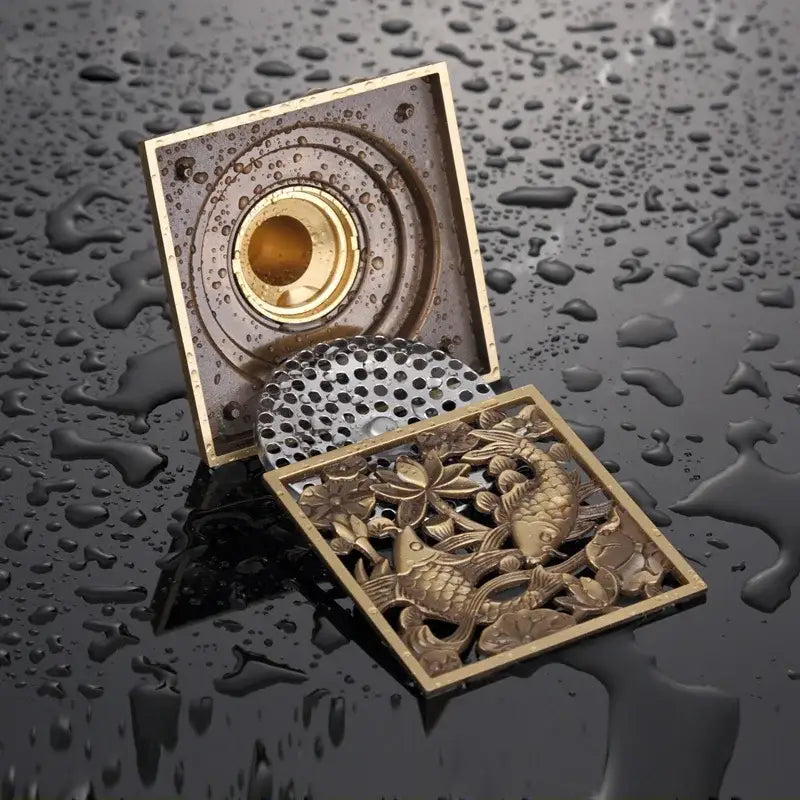 Antique brass square fish carved floor drain with ornate lotus design and perforated metal cover for bathroom use